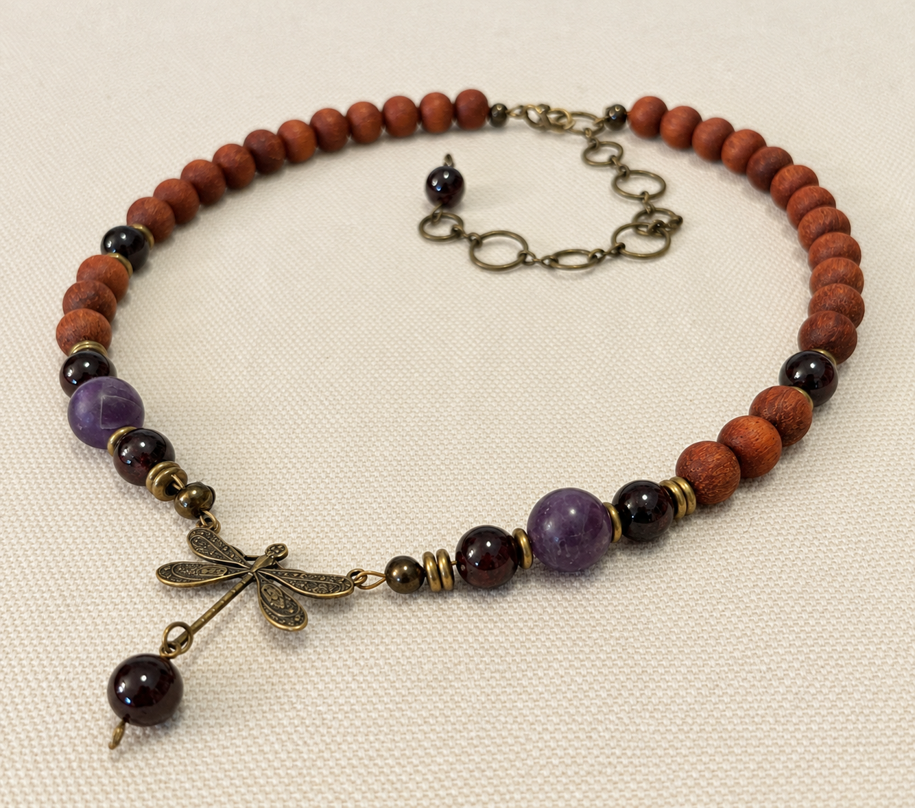 Wings of Renewal Choker necklace of a bronze dragonfly, and amethyst, garnet and brown wooden bayong beads